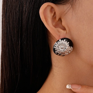 Detail shot of vintage style metal daisy stud earring worn on a model's ear