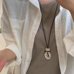 Collier minimaliste en acrylique avec perle crème et anneau irrégulier en argent