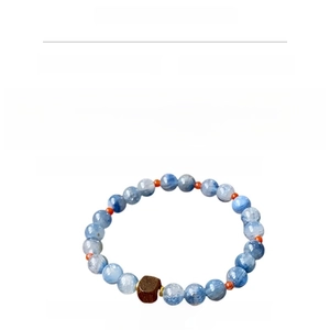 Macro detail of natural blue crystal beaded bracelet with dark wood barrel charm
