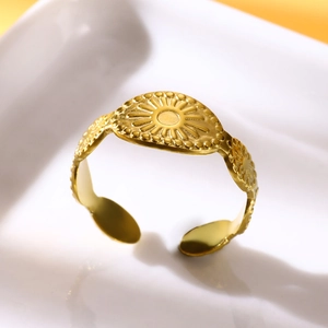 Detail of adjustable gold ring featuring an embossed sunflower eye design on ceramic