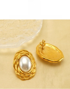Detailed view of vintage gold stud earrings with large white pearl and twisted metal border