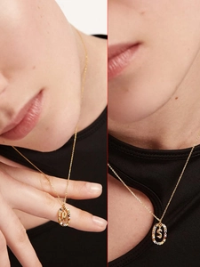 Detail of gold oval crystal necklaces with letters M and S shown on models