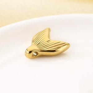 Close-up of golden stainless steel mermaid tail pendant showing detailed texture
