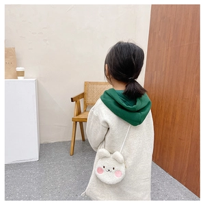 Detail view of the soft plush white animal crossbody bag on a child model with sheep wool texture