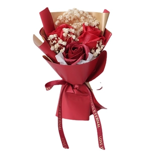Mini bouquet of red soap roses and dried gypsophila in red and gold gift wrap