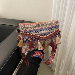 Detail of bohemian crossbody bag featuring colorful geometric patterns and fringe tassels