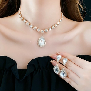 Dettaglio del set di collana e orecchini con cristalli a goccia in finitura dorata