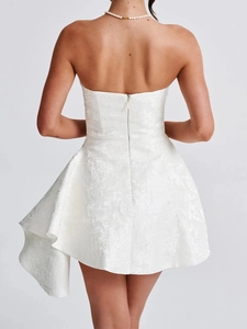 Detail of white strapless mini dress featuring textured jacquard fabric and asymmetric hem