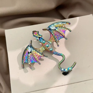 Macro view of rainbow dragon brooch with sparkling rhinestones on off-white card