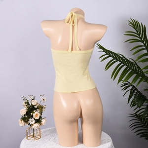 Λεπτομέρεια κίτρινου πλεκτού halter top με σχέδιο με κορδόνια στην ανοιχτή πλάτη