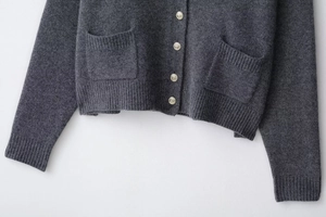 Détails du cardigan en laine gris foncé avec boutons dorés embossés et poches en maille