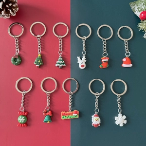 Detailed overhead view of diverse Christmas keychains including Santa, trees, and bells