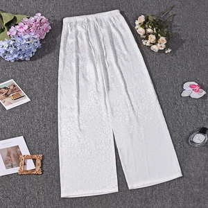 Detailed view of white satin wide-leg pants with leopard jacquard and drawstring waist