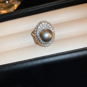Macro shot of a black pearl ring with double zircon pavé set in a silver band