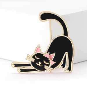 Macro detail of cute black enamel cat brooch with gold trim and pink accents on suit jacket