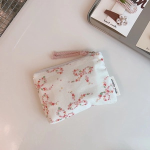 Detailed macro view of a floral cotton coin purse with pink bow prints and zipper
