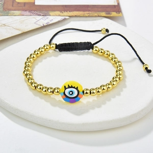 Handmade evil eye bead bracelet with gold beads and adjustable cord on marble
