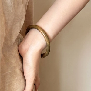 Vue détaillée du bracelet jonc circulaire en bois sculpté avec grain naturel de bois brun