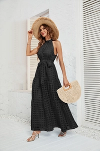 Detailed close-up of black halter tiered maxi dress with textured fabric and tie waist