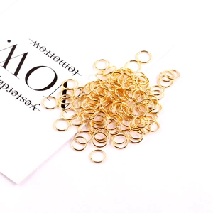 Overhead view of golden open jump rings for DIY jewelry making on white background