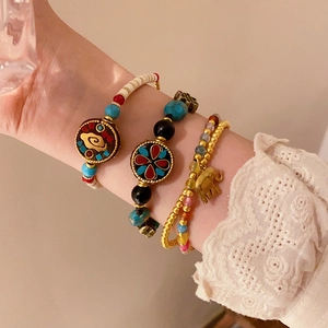 Détails de bracelets ethniques en perles avec breloques éléphant portés au poignet