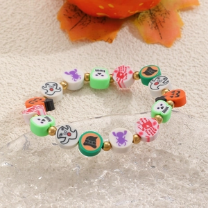Primer plano detallado de la pulsera de Halloween con cuentas de arcilla y dijes de calabaza
