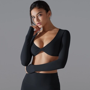 Dettaglio dell'incrocio frontale sulla maglia da yoga nera a maniche lunghe e leggings