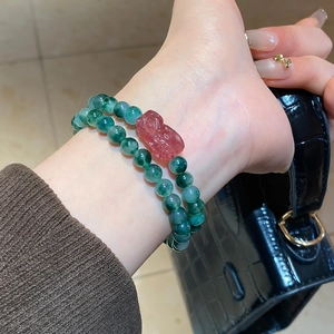 Detailed close-up of double-layer agate beaded bracelet with red PiXiu charm on wrist