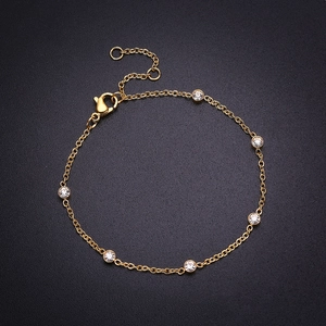 Bracelet élégant en acier titane doré avec six zircons ronds sur fond noir texturé