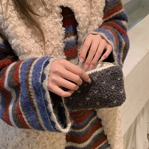 Close-up of fluffy dark grey polka dot plush makeup bag showing soft texture and zip