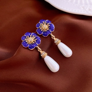 Detail of blue enamel flower earrings with crystal center and white teardrop pearl drops