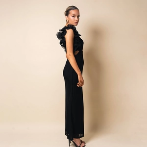 Détail de la robe moulante en tulle noir avec épaule à volants et découpe à la taille
