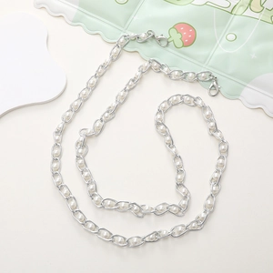 Detail of silver metal chain with white pearls and lobster clasps on phone lanyard