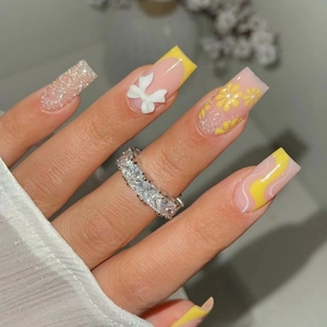 Long square press-on nails with yellow floral patterns and 3D white bow designs