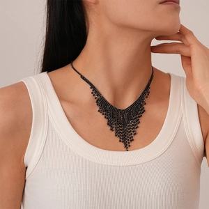 Detail of dark gothic style fringe necklace with black rhinestones on a female model