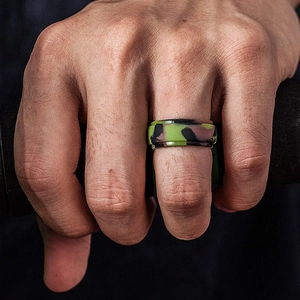 Close-up of a camouflage silicone ring for men worn while holding gym equipment