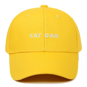 Detailed close-up of CAT DAD white embroidery on a vibrant yellow cotton baseball cap