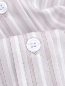 Detail of light brown striped fabric with a white four-hole button on the shirt front