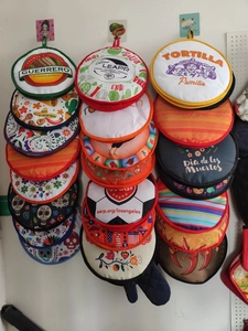 Hanging display of colorful fabric tortilla warmers with various printed patterns