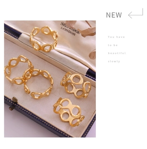 Close-up of five hollow gold rings in a vintage luxury box with floral accents