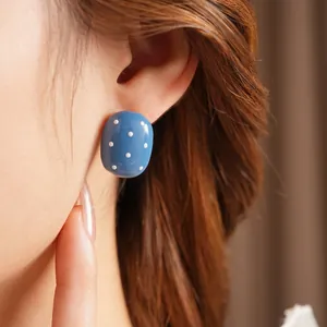 Elegant retro oval earrings in bright blue with white polka dots for a vintage aesthetic