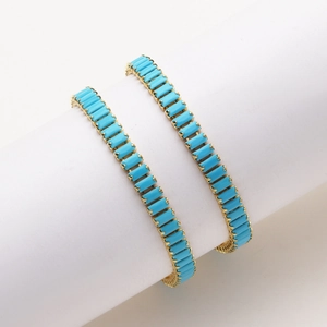 Detail of 18K gold-plated tennis bracelets featuring blue turquoise rectangle stones