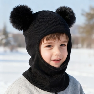 Detail of kids black knitted balaclava with dual faux fur pom-poms for winter warmth