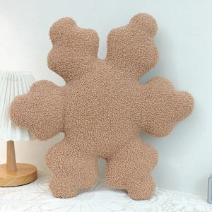 Brown snowflake pillow made of soft teddy boucle fabric in a cozy home setting decor