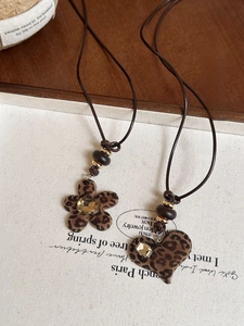 Detailed macro view of leopard print heart and flower resin pendants with rhinestones