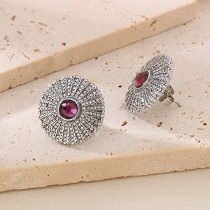 Detailed macro view of silver sunburst earrings with purple stones and white rhinestones
