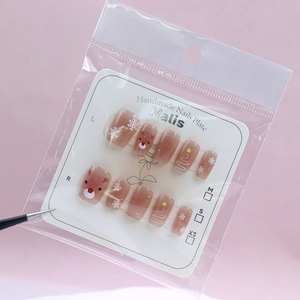 Christmas press-on nails with reindeer and snowflake cat-eye design on brown base