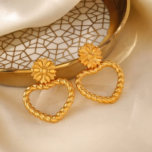 Boucles d'oreilles cœur tournesol plaquées or 18 carats sur satin champagne et plateau doré