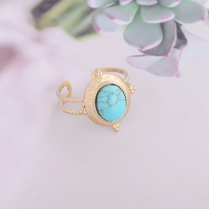 Detailed close-up of a vintage gold-toned ring with oval turquoise stone and twisted band