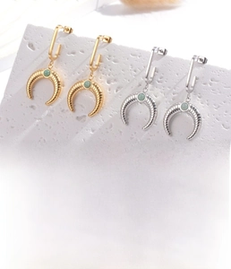 Detail view of gold and silver croissant earrings with zircon inlay in 10g titanium steel